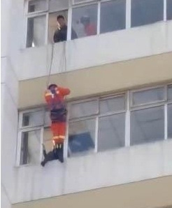 女子欲跳楼被踹回 消防员10楼速降一脚将该女子踹进室内[图]
